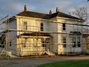 Older Calgary home under renovation with exterior scaffolding, representative of houses built before 1990 that may contain asbestos materials