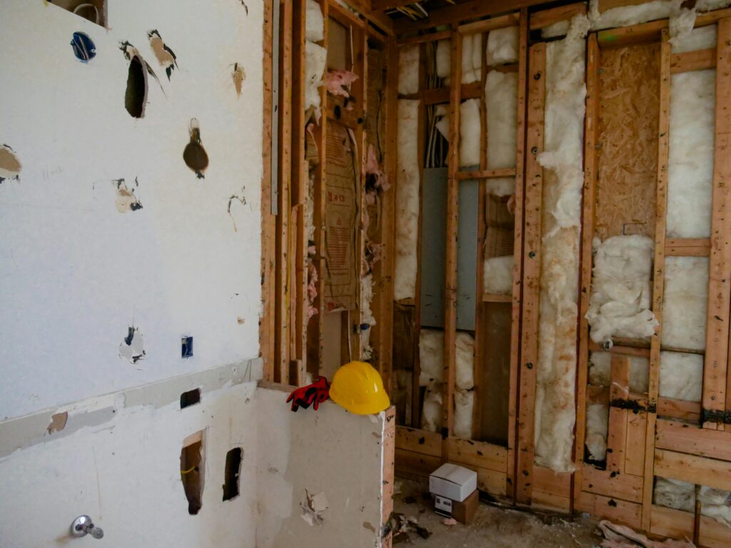 Interior demolition area with exposed wall studs, insulation, and partially removed drywall